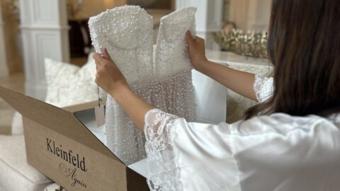 A bride admires her new pre-owned dress from Kleinfeld Again.